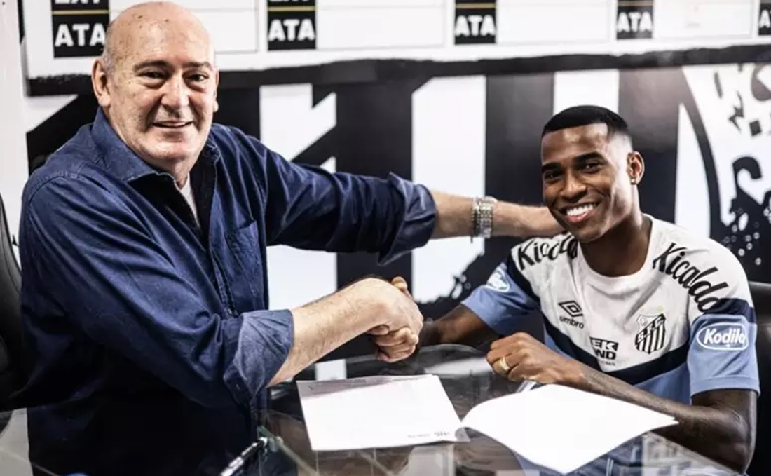 Rueda e o jogador de futebol assinando papelada da contratação (Foto: Reprodução/ Divulgação/ Santos FC)