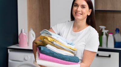 Mulher com várias roupas na mão (Foto: Reprodução/ FreePik)